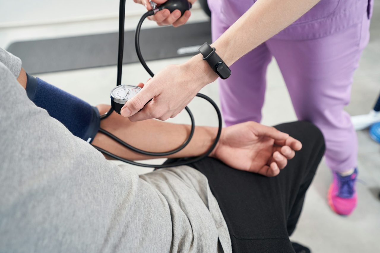 Home 3 female doctor measuring patient blood pressure in clinic